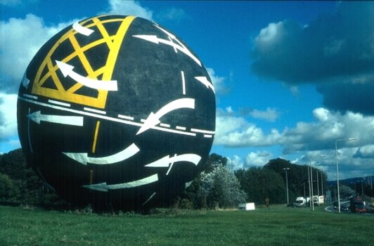 Round globe with arrows and markings painted in yellow and white.