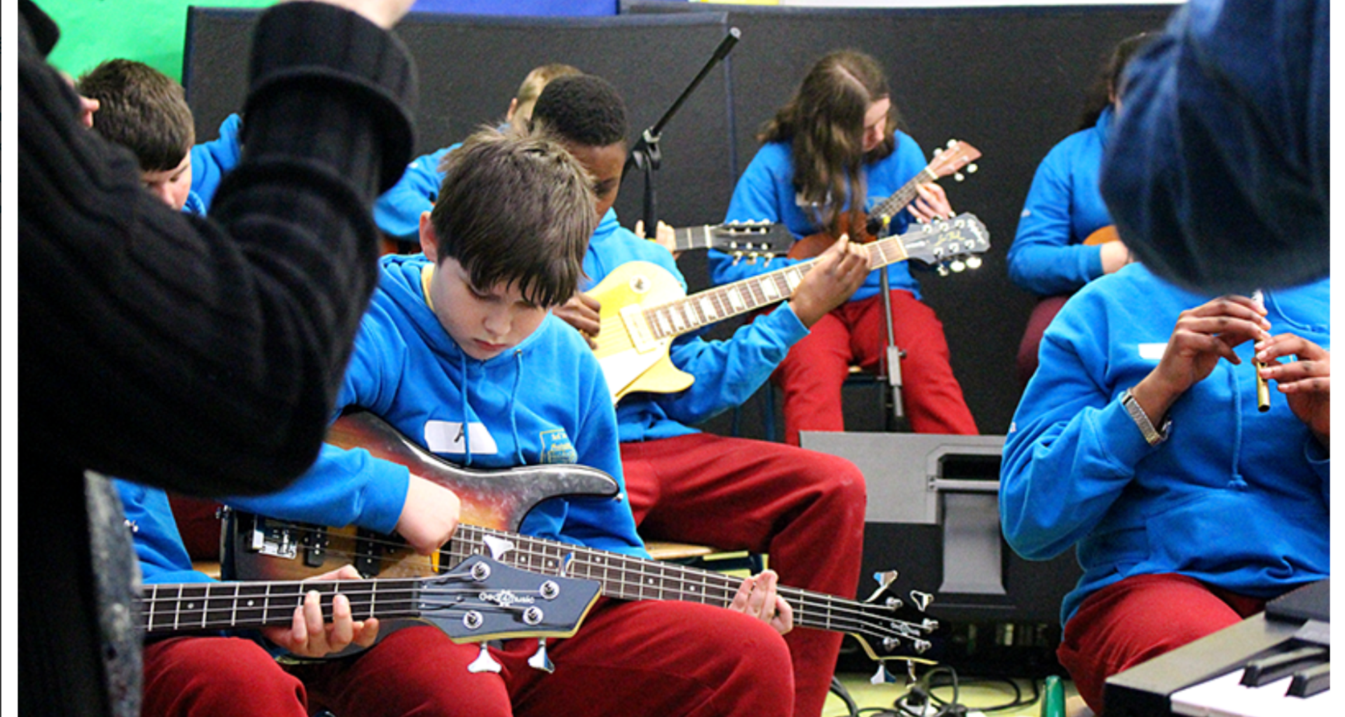 Students playing guitar in a group as a performance.